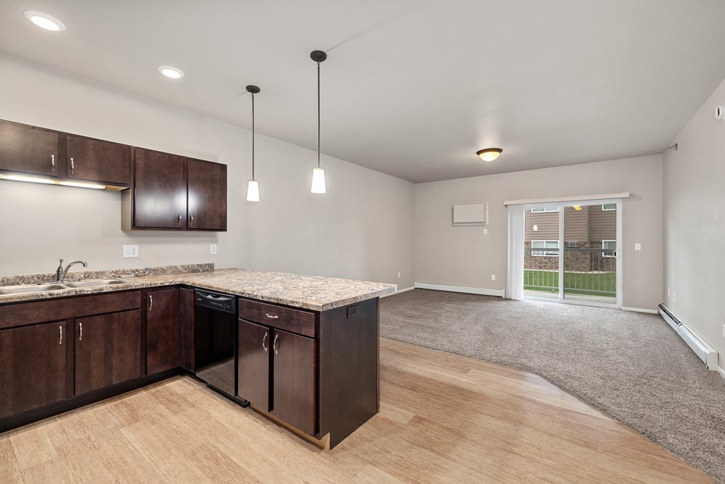 A kitchen with wooden cabinets and a granite countertop.
