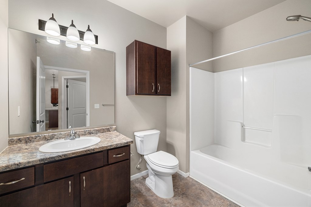 A bathroom with a sink, toilet, and bathtub.