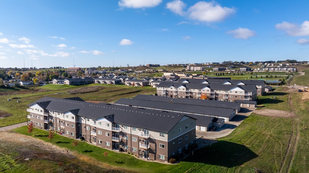 A large building complex with multiple buildings and a grassy area in front.