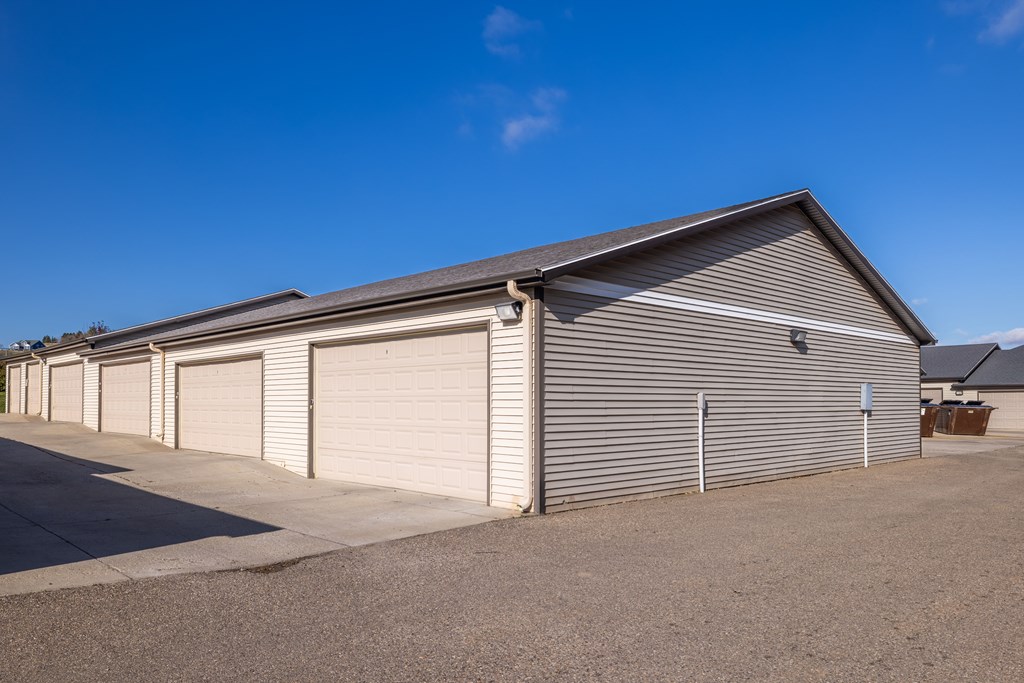 A long building with a grey roof and a sign on it.