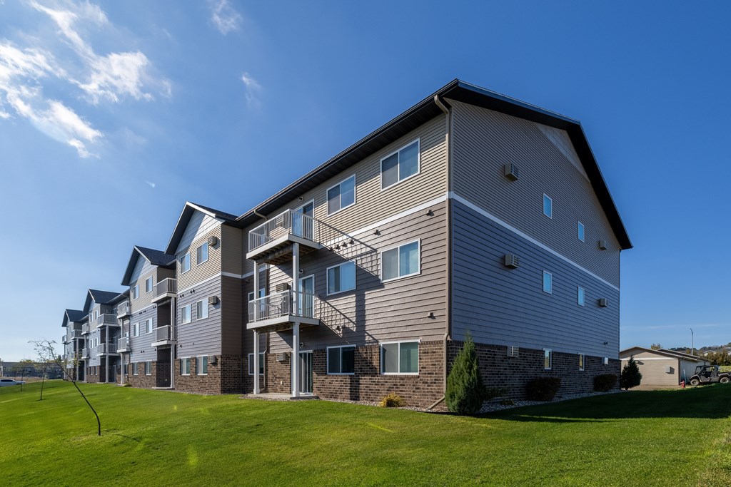A large apartment building with a grassy area in front.