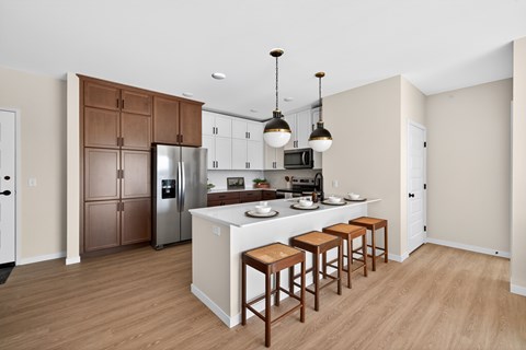 A kitchen with a white island and brown cabinets.