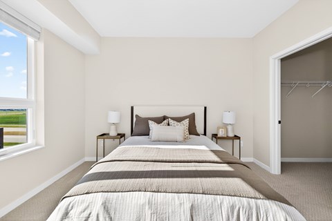 A bedroom with a large bed and two lamps on side tables.