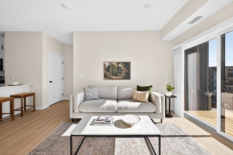A living room with a couch, a coffee table, and a painting on the wall.