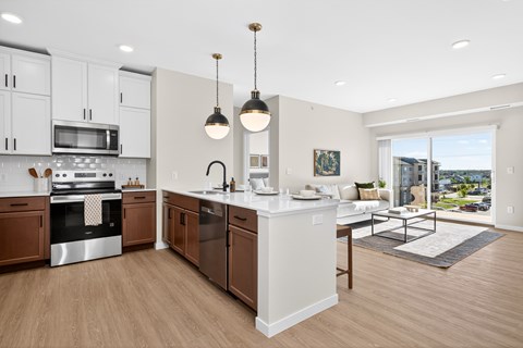 A modern kitchen with wooden floors and white walls.