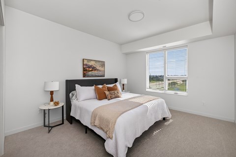 A bedroom with a large bed and a painting on the wall.