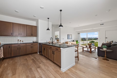 A modern kitchen with wooden floors and a large island.