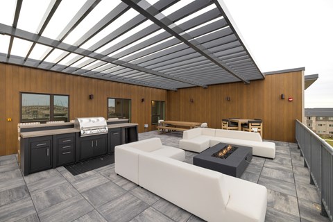 A modern outdoor living space with a white couch and a fireplace.