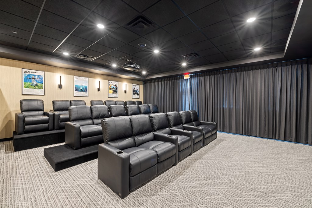 A row of black leather seats in a movie theater.