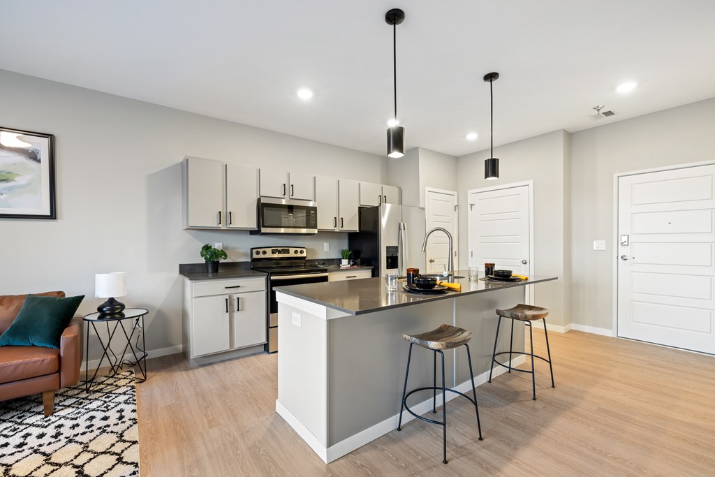 A modern kitchen with a bar stool and a chair.