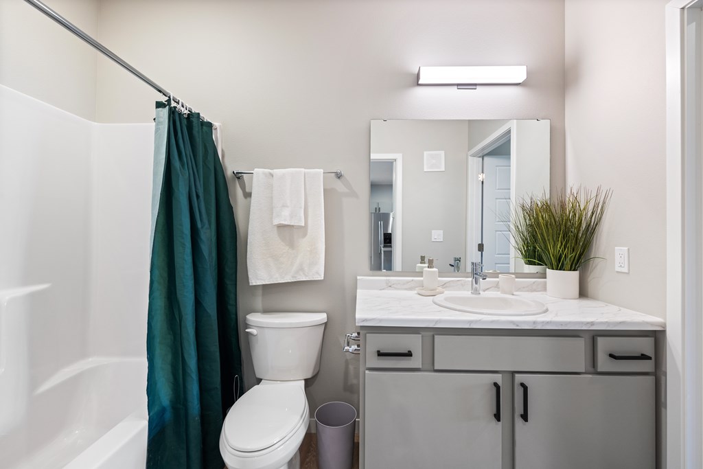 A bathroom with a white toilet, a white sink, and a white bathtub.