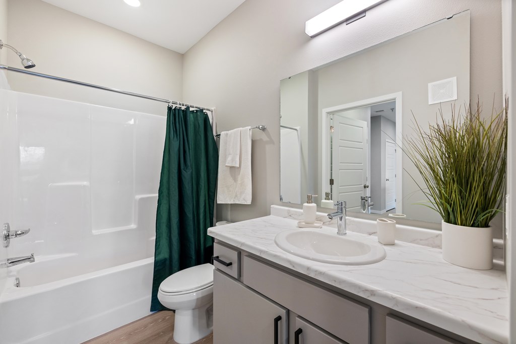 A bathroom with a white toilet, a white sink, and a white bathtub.