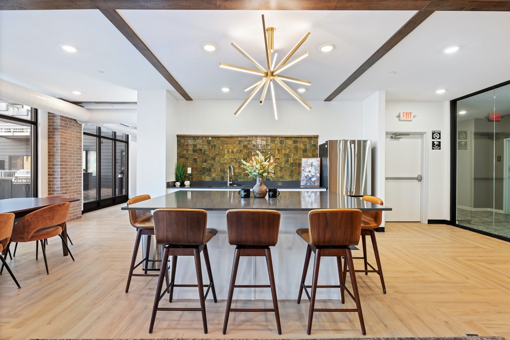 A modern kitchen with a bar area and wooden chairs.