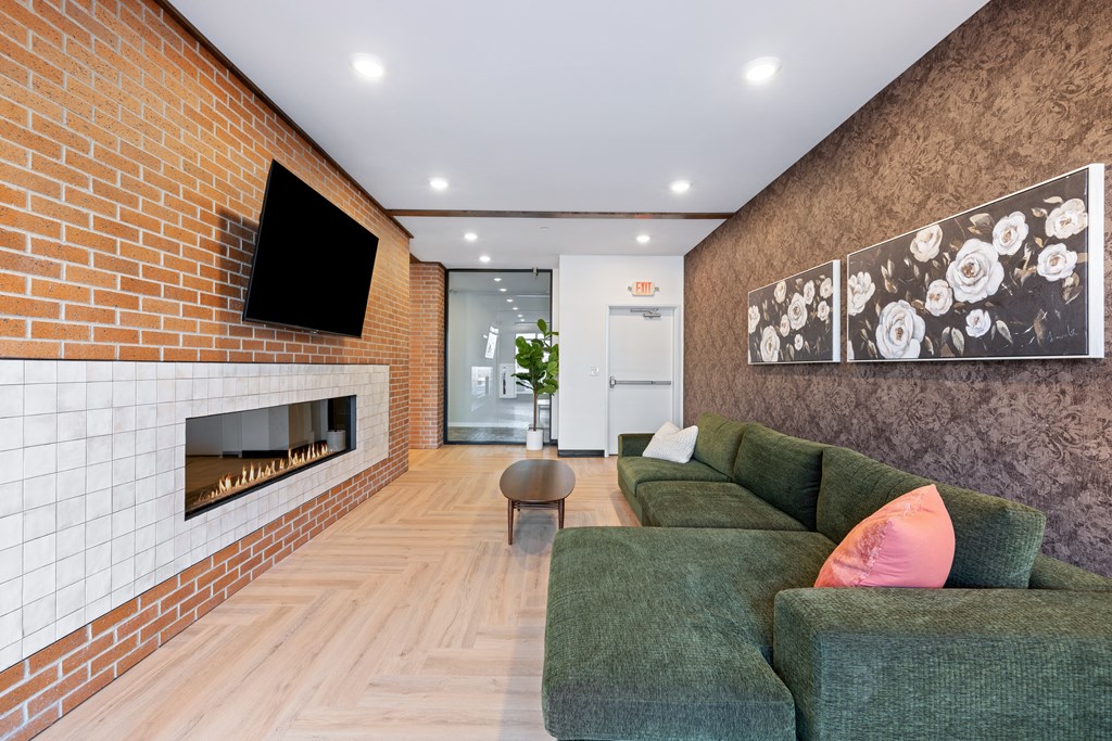A living room with a green couch and a fireplace.