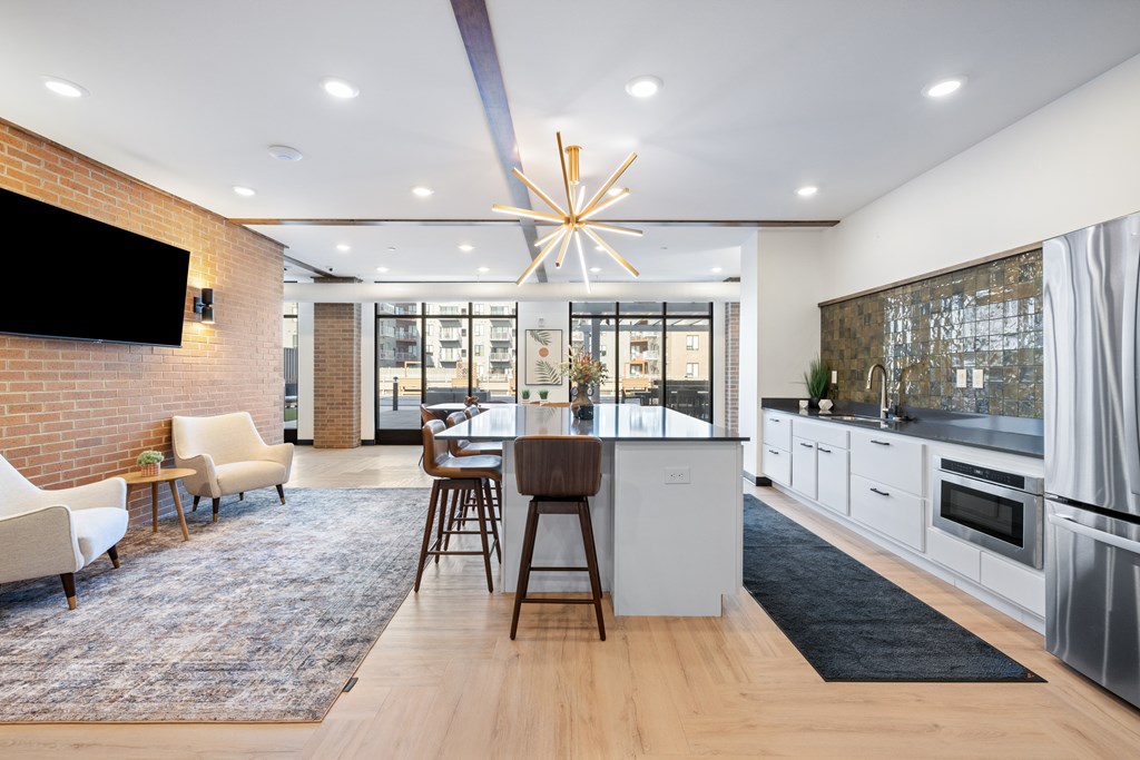 A modern kitchen with a dining area and a television on the wall.