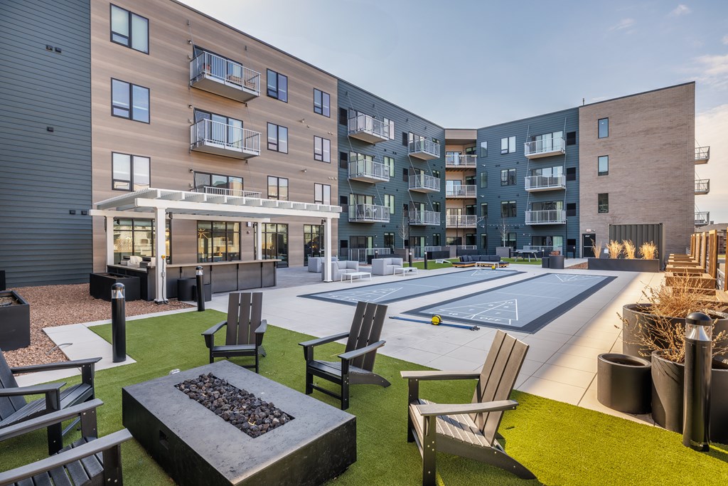 A modern apartment complex with a fire pit in the courtyard.