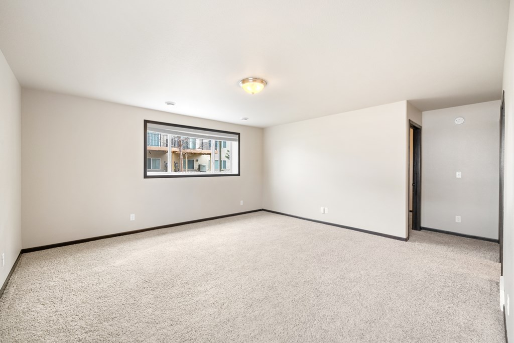 A spacious room with a framed picture on the wall and a carpeted floor.