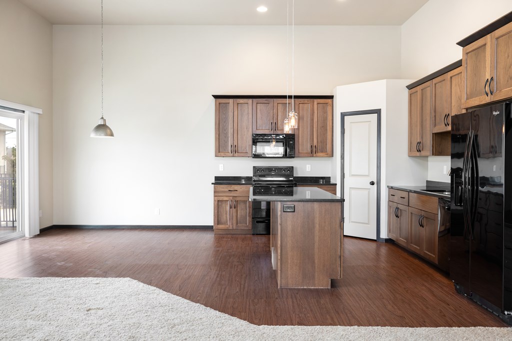 A kitchen with wooden cabinets and black appliances.