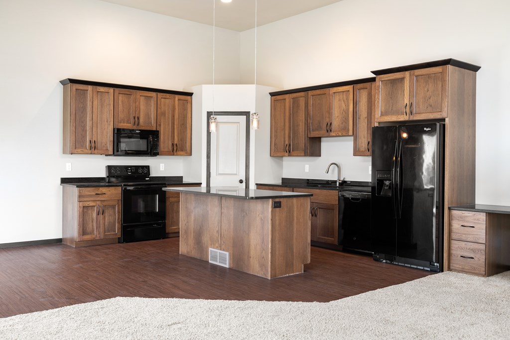 A kitchen with wooden cabinets and black appliances.