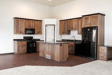 A kitchen with wooden cabinets and black appliances.