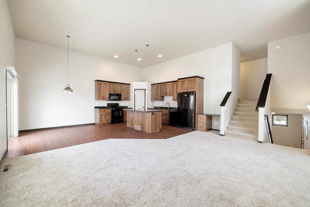 A spacious living room with a staircase leading to the upper floor.