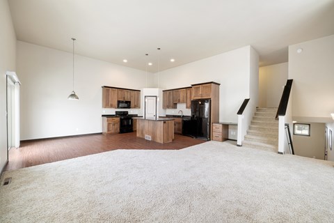 A spacious living room with a staircase leading to the upper floor.