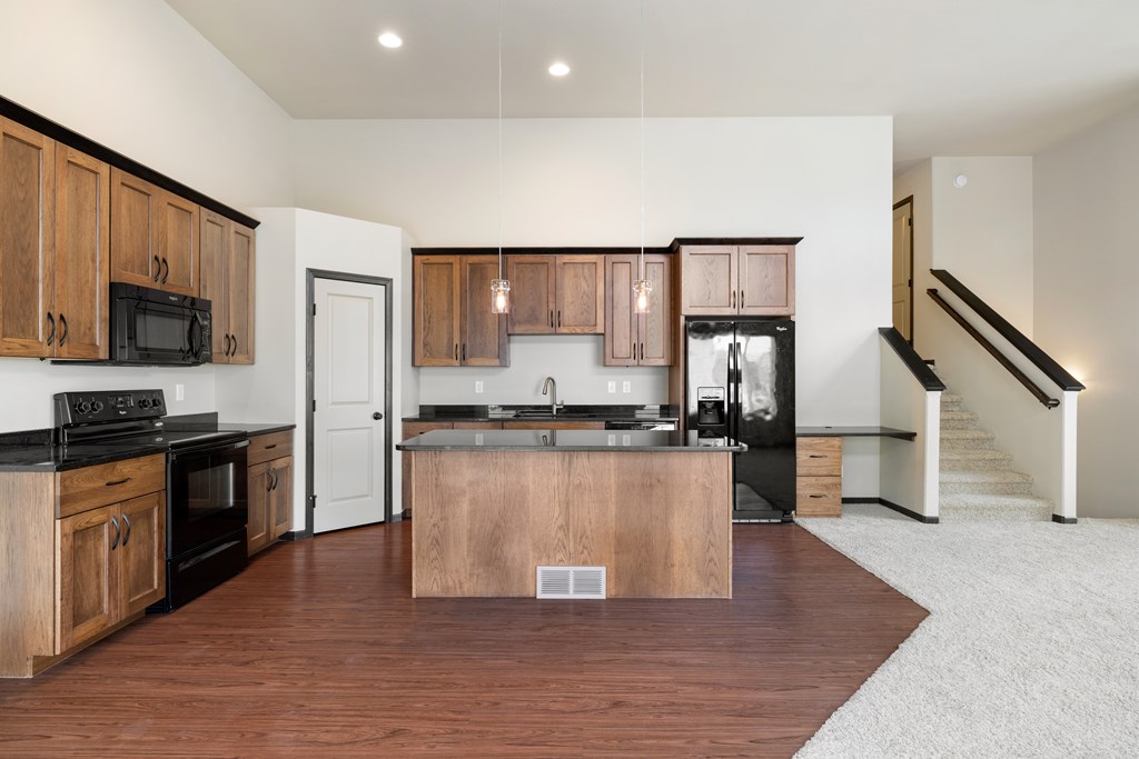 A kitchen with wooden cabinets and a black countertop.