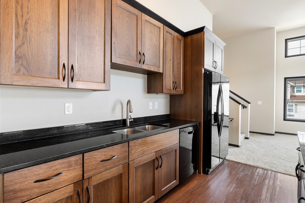 A kitchen with wooden cabinets and black countertops.