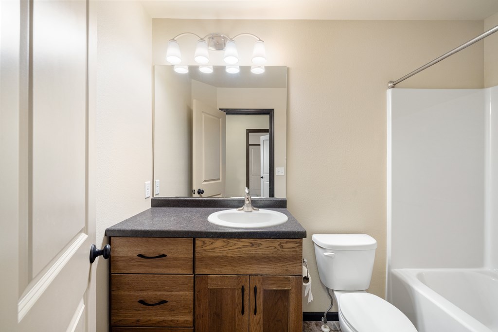A bathroom with a sink, toilet, and bathtub.