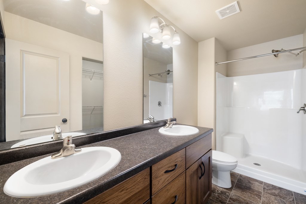 A bathroom with a sink, mirror, toilet and bathtub.