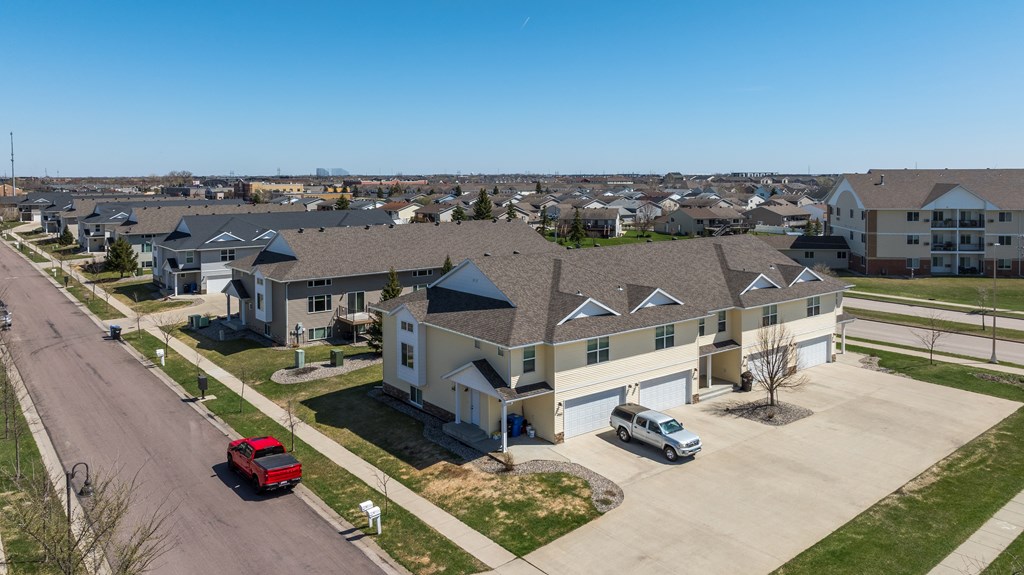 A residential street with houses and cars on a sunny day.