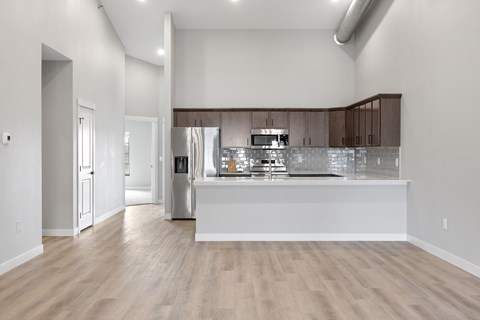 A kitchen with a white counter and wooden floors.