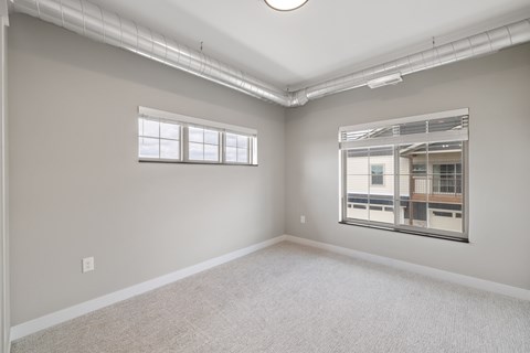 A room with a window and a view of a building outside.