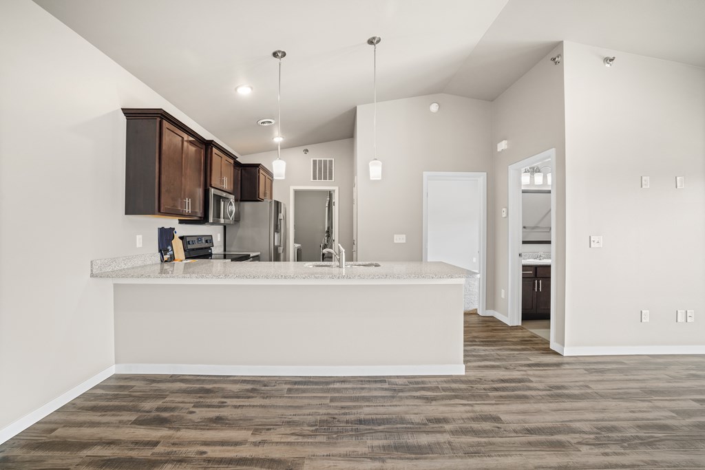 A kitchen with a white counter and brown cabinets.