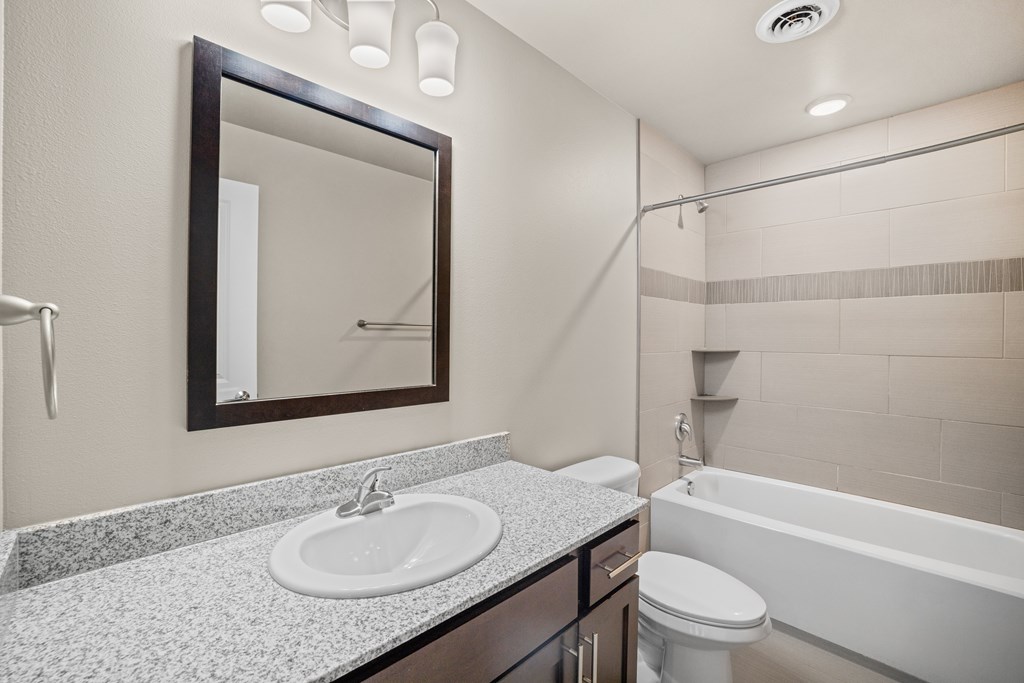 A bathroom with a sink, toilet, and bathtub.