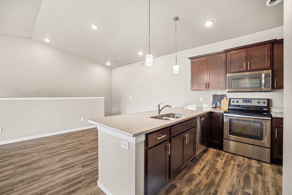 A kitchen with wooden floors and a white counter top.