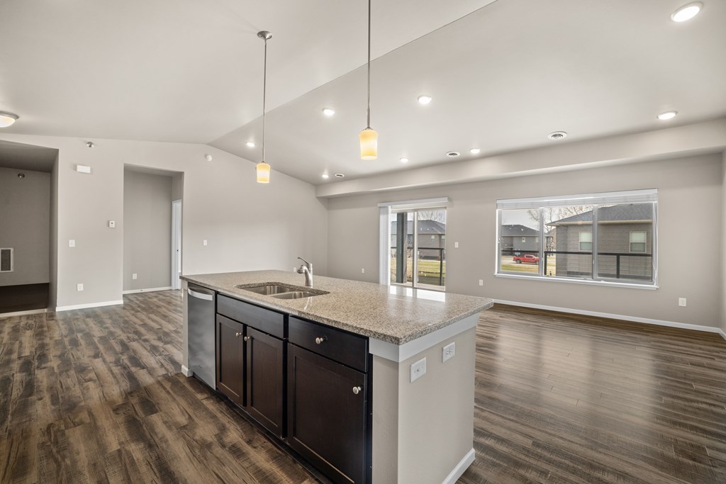 A modern kitchen with dark wood floors and a large island.