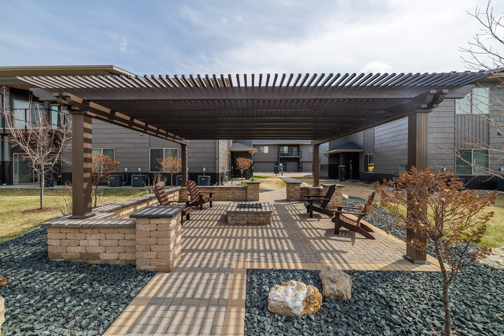 A patio area with a table and chairs under a roof.