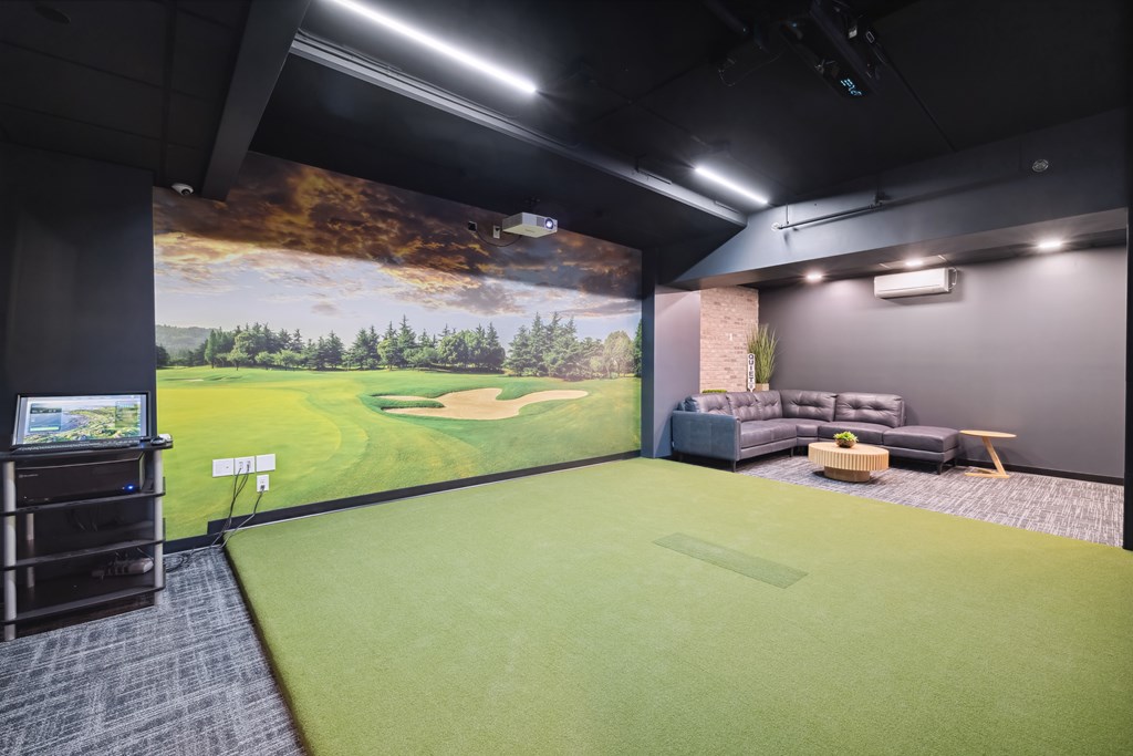 A golf simulator room with a mural of a golf course.