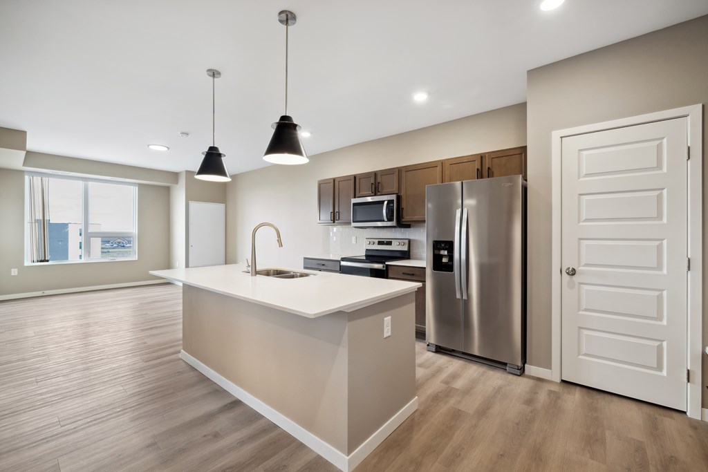 A kitchen with island and brown cabinets.