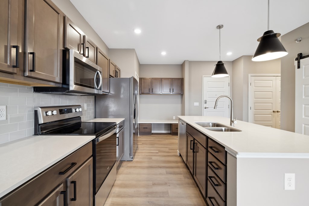 A kitchen with island and brown cabinets.