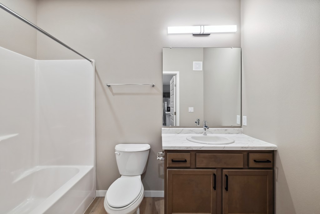 A bathroom with wood toned vanity
