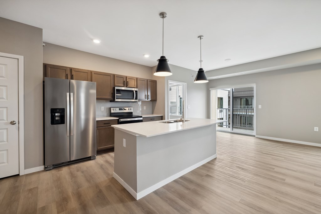 A kitchen with island and brown cabinets.