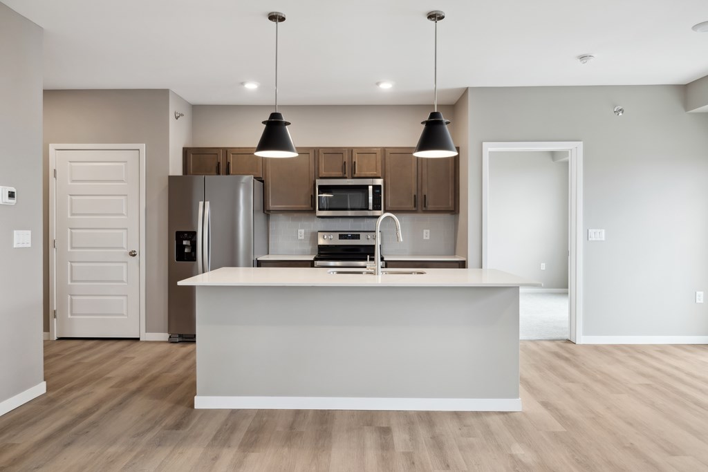 A kitchen with island and brown cabinets.