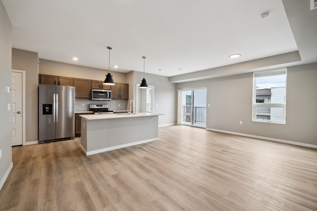 A kitchen with island and brown cabinets.