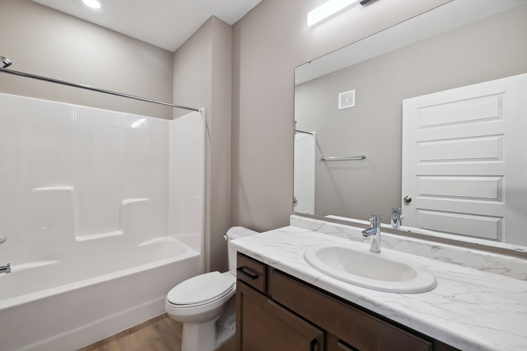 A bathroom with wood toned vanity