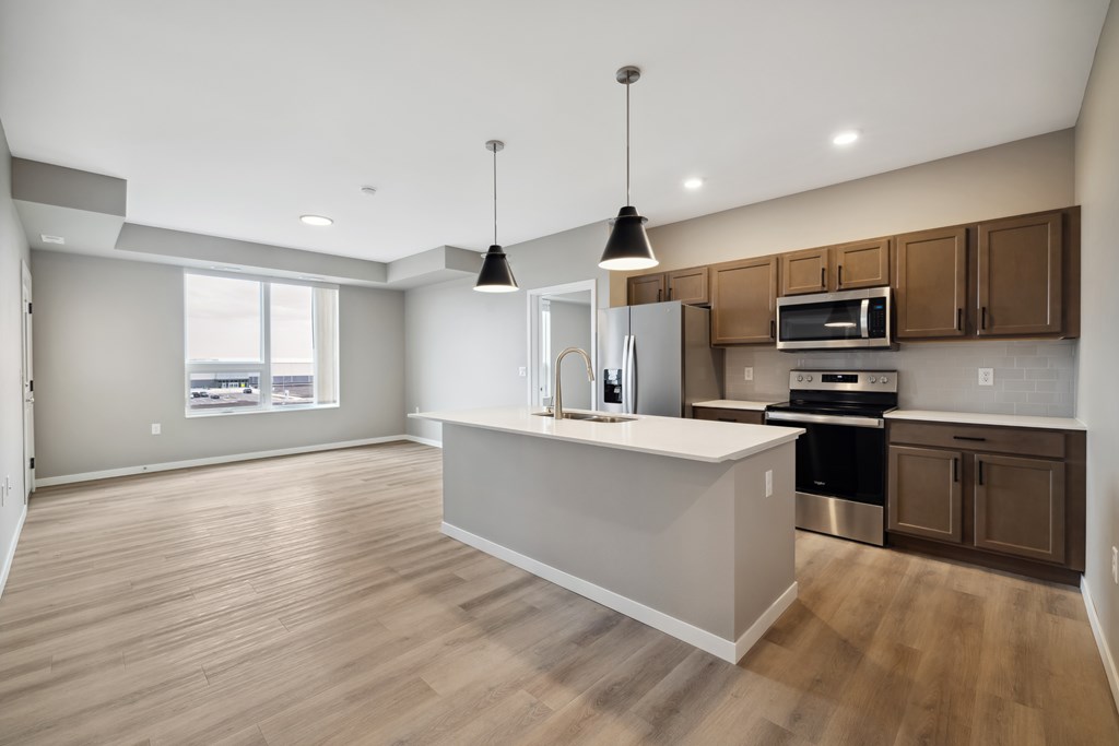 A kitchen with island and brown cabinets.