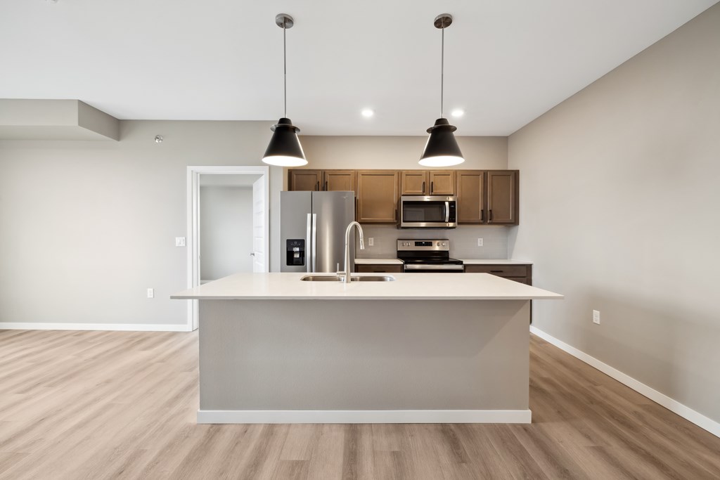 A kitchen with island and brown cabinets.