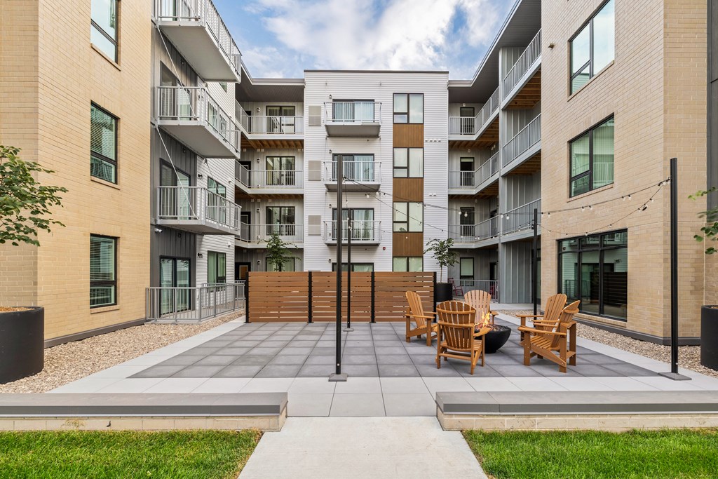A modern apartment complex with a central courtyard and seating area.