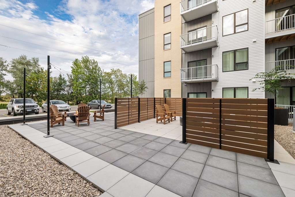 A modern outdoor patio area with a wooden fence and chairs.
